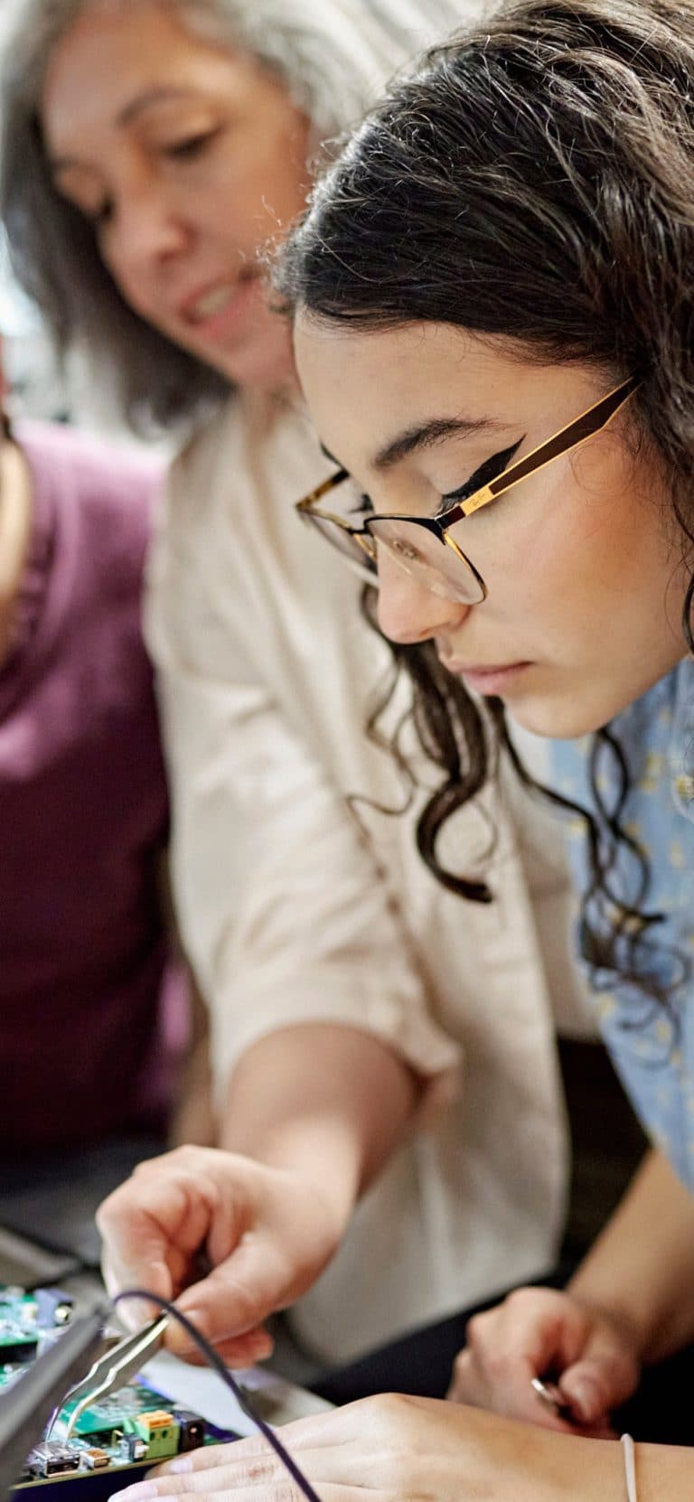 A student and professor in an electronics class