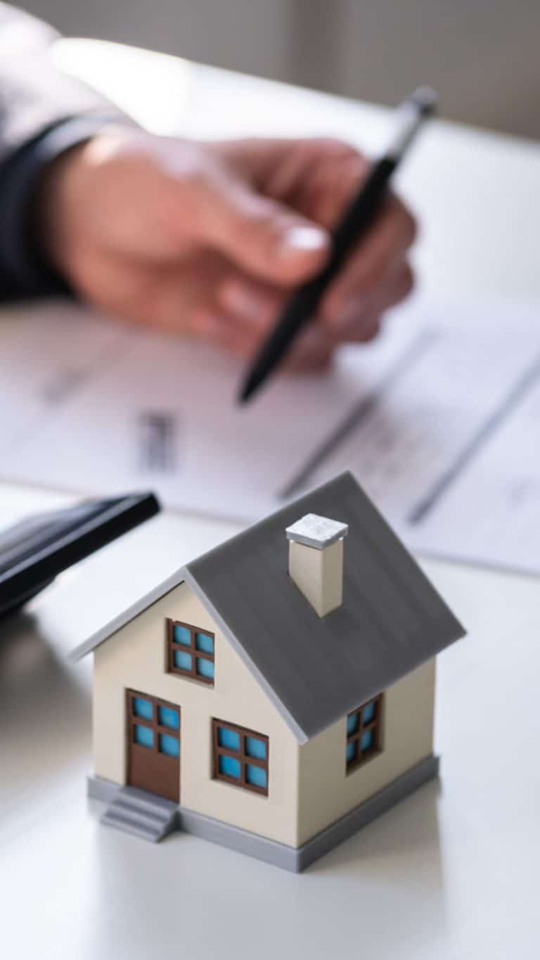 An image showing someone working on property taxes with a model of a house in the foreground.