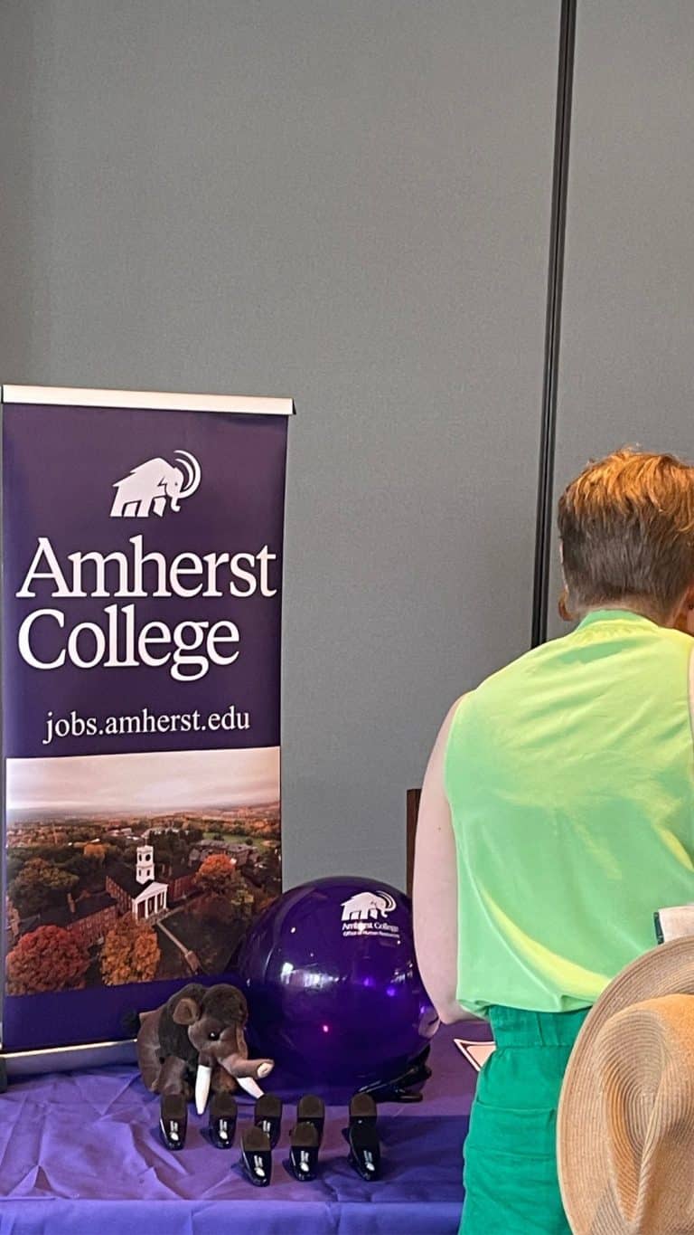 An employment candidate speaks to a representative of Amherst College at the Five Colleges Job Fair, June 5, 2025